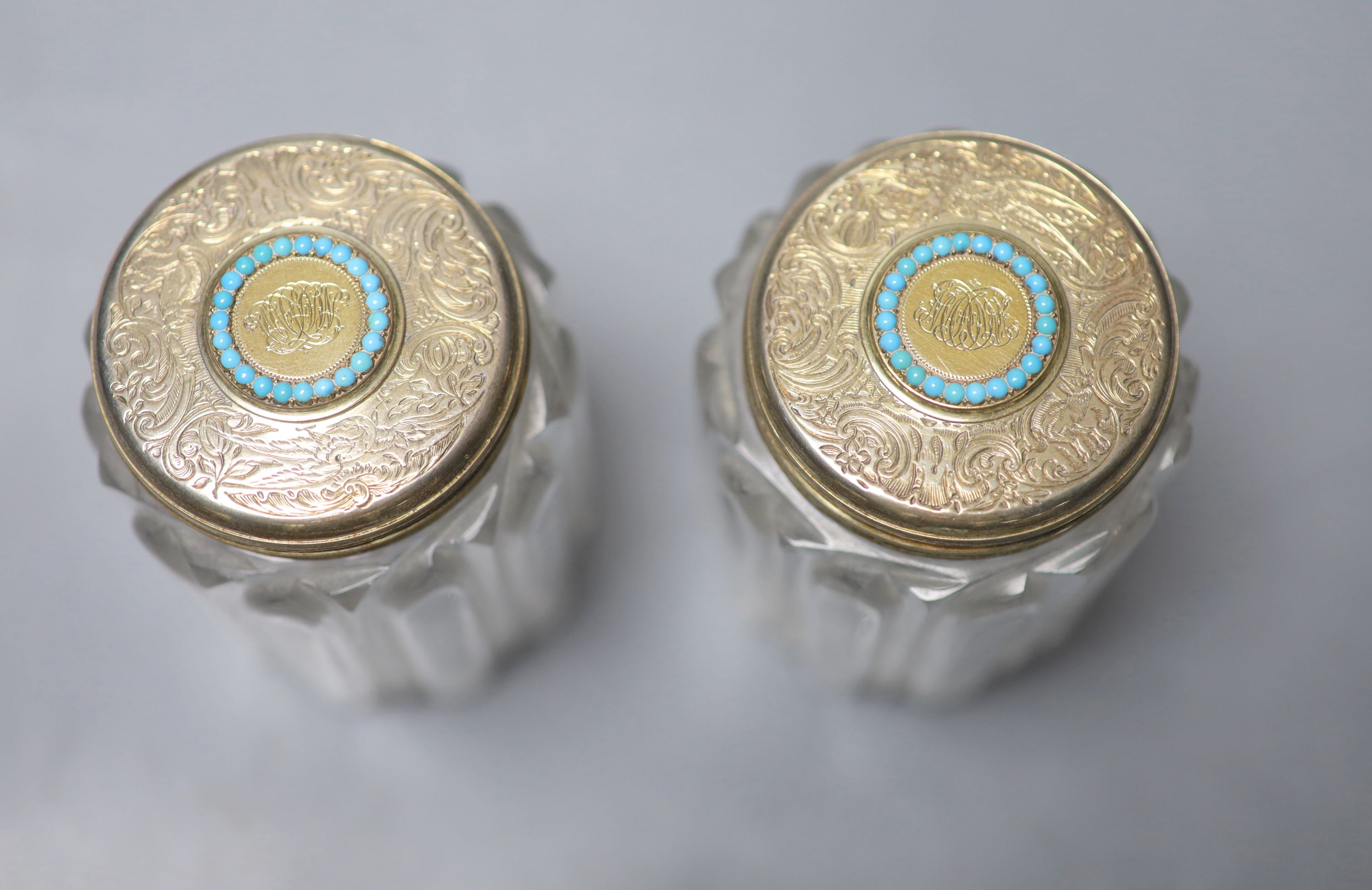 A pair of Victorian silver gilt and turquoise lidded glass cylindrical toilet jars, John Harris, London, 1854, 9.8cm.